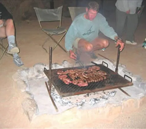 Nach einem erlebnisreichen Tag ist der beste Platz am Lagerfeuer, während Euer Guide Euch zeigt, wie' schmackhaft "Buschküche" sein kann...