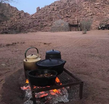 Ihr Lagerfeuer im Camp -Treffpunkt zu Mahlzeiten, für einen Plausch und um sich zu wärmen. Afrikanische Nächte können recht frisch sein...
