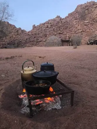 Ihr Lagerfeuer im Camp -Treffpunkt zu Mahlzeiten, für einen Plausch und um sich zu wärmen. Afrikanische Nächte können recht frisch sein...